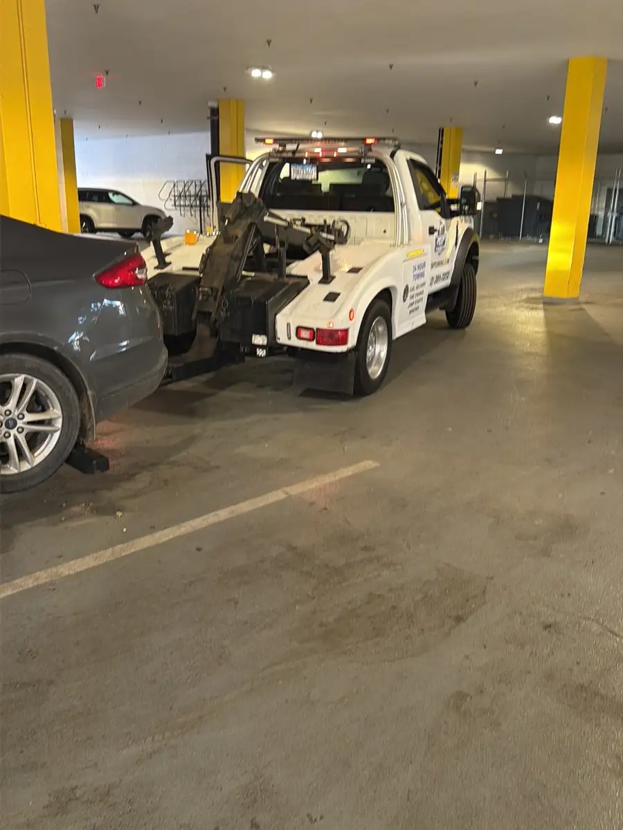 MSP Towing truck assisting a sedan inside a parking ramp